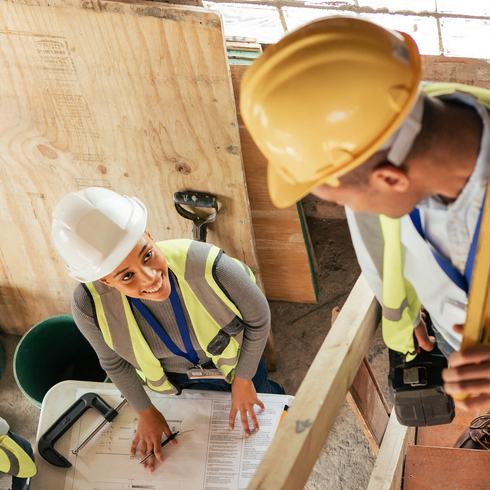 Travailleurs de la construction sur le chantier d’une maison en train de consulter des plans Travailleurs de la construction sur le chantier d’une maison en train de consulter des plans